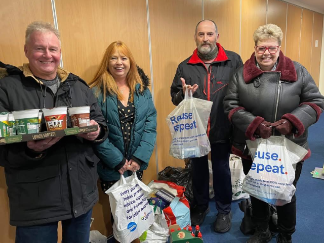 Volunteers holding food donations.