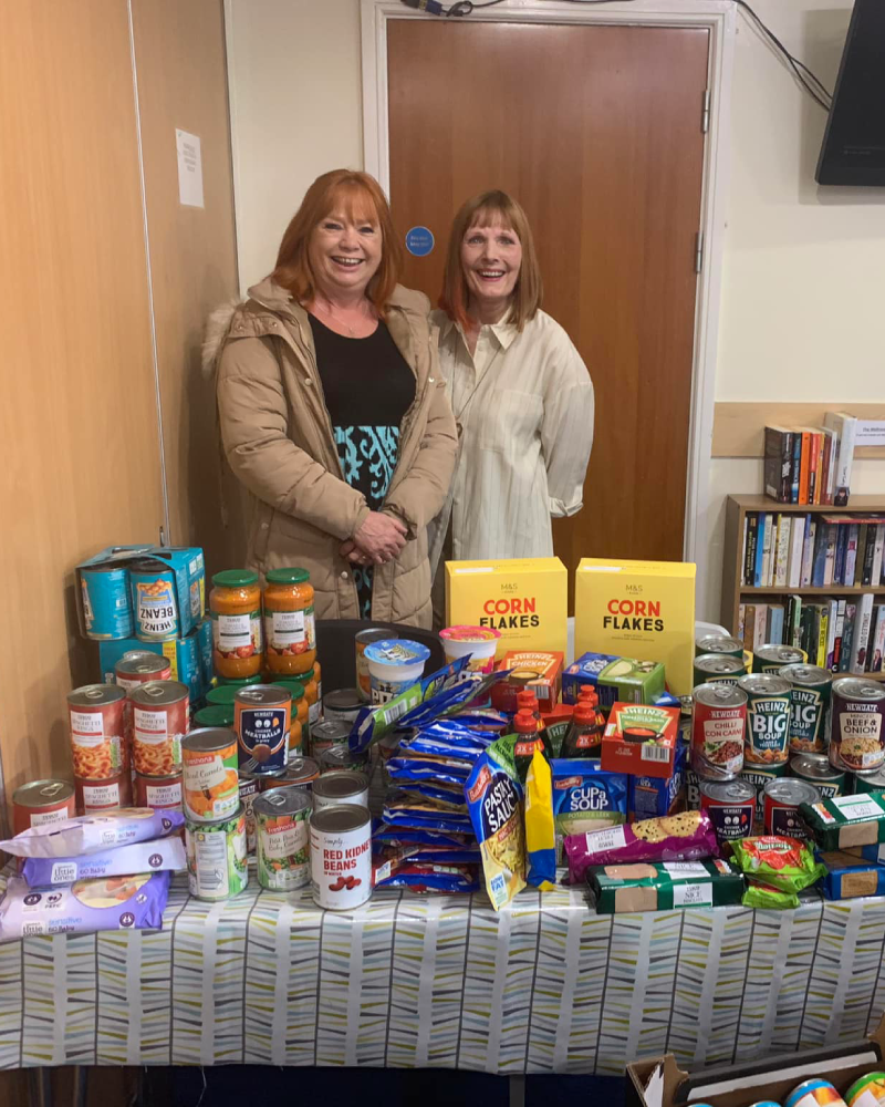 Volunteers standing alongside donated food.